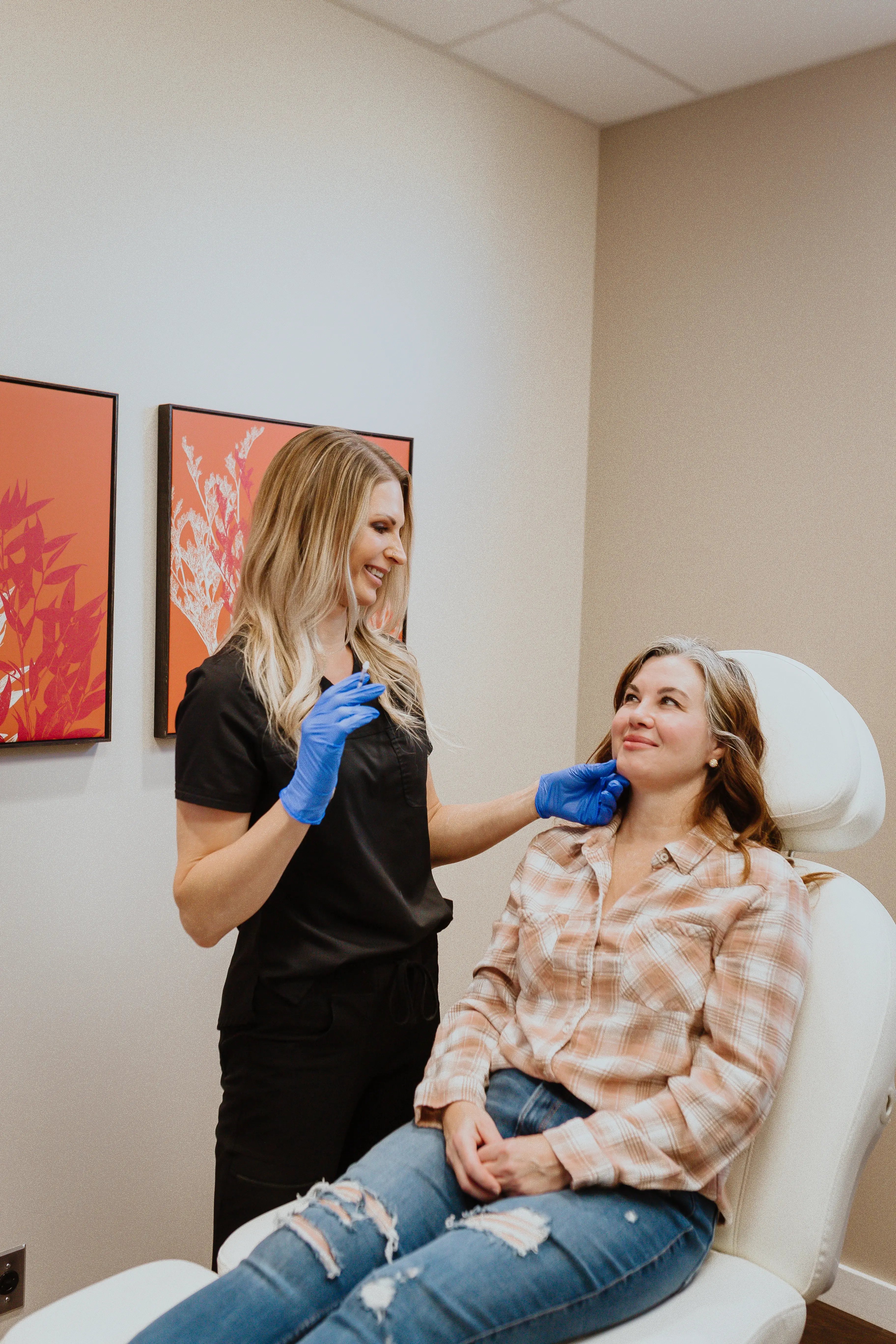 clinician-in-black-scrubs-with-blue-gloves-examining-patients-chin-on-exam-chair-while-discussing-does-sculptra-really-work