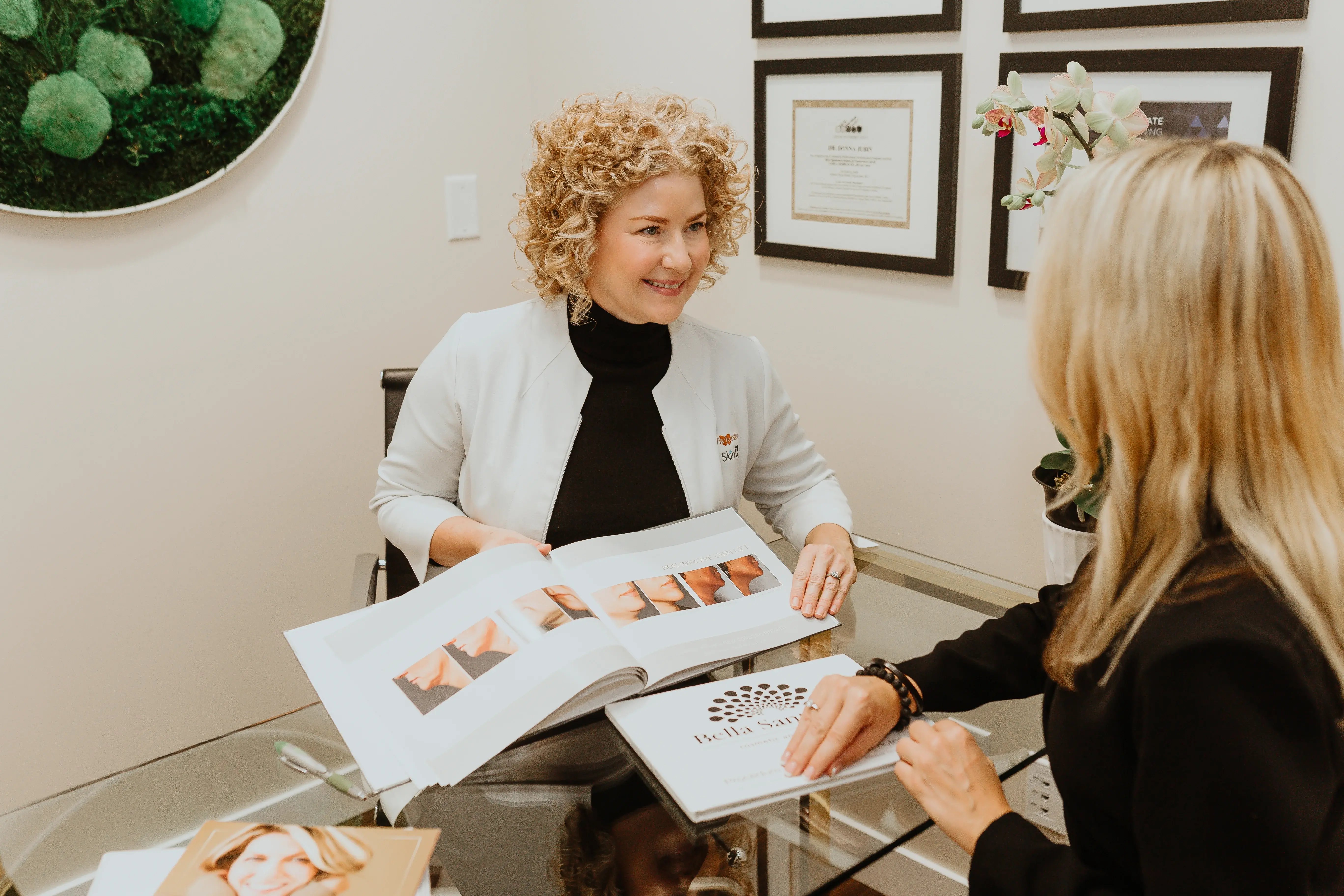 medical-provider-consulting-patient-at-glass-desk-reviewing-before-after-photos-during-aptos-thread-lift-consultation