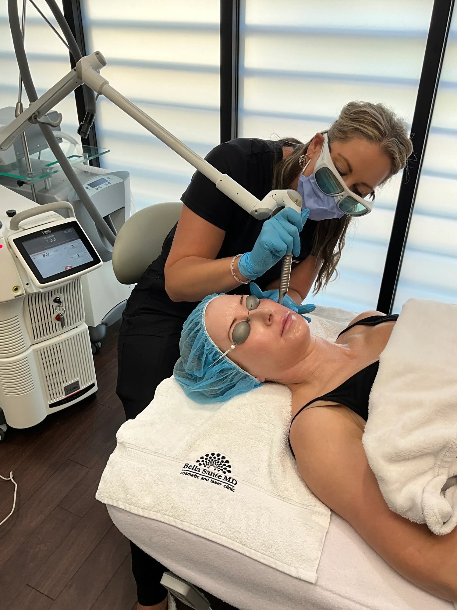 photo-practitioner-performing-laser-facial-treatment-on-woman-wearing-eye-protection-lying-on-clinic-bed-with-equipment-nearby photo-practitioner-performing-laser-facial-treatment-on-woman-wearing-eye-protection-lying-on-clinic-bed-with-equipment-nearby