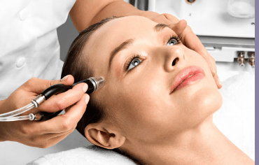 photo-woman-receiving-facial-treatment-with-handheld-device-microdermabrasion-saskatoon-clinic-setting-technician-hand-supporting-forehead-close-up-of-skin-procedure